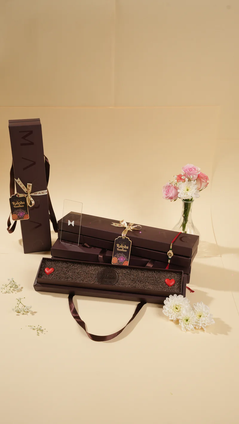 Stacked Maybac chocolate gift boxes with ribbons and flowers