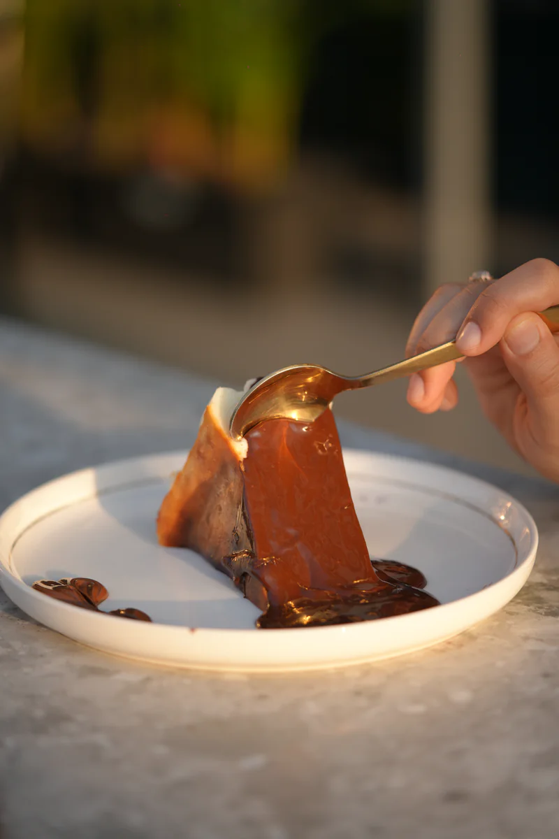 Chocolate raclette poured over basque cheesecake