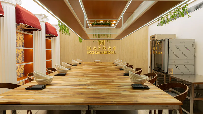The Maybac Bakery & School teaching kitchen with a long wooden table