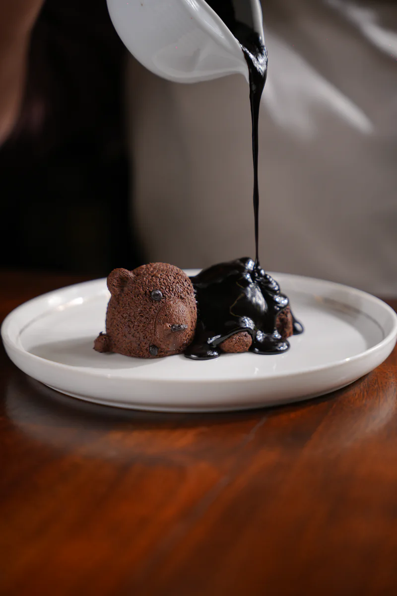 Warm chocolate poured over the Sleeping Teddy mousse